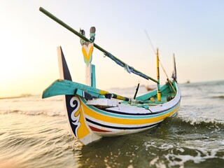 The boat is parked at the edge of the beach