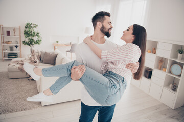 Photo of cheerful cute young couple enjoy weekend couple husband hold wife gentle buy new apartment indoors inside house home