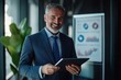 © Vooglo.com - Mature older business man executive manager using digital tablet standing in office