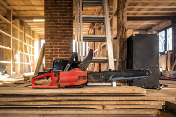 Professional carpenter chainsaw on the wooden board on construction site