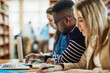 © SometimesNever/peopleimages.com - Laptop, notes and friends studying at library for education, knowledge or test preparation in college. University students, man and learning on computer for help, project research and online report
