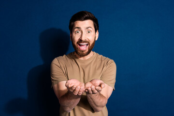 Sticker - Photo of impressed ecstatic man with beard dressed beige t-shirt palms hold object empty space isolated on dark blue color background