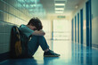 © Alexandra - Young student is sitting alone on the floor of a school hallway, feeling sad and overwhelmed