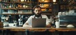 © yachyah - Barista Working on Laptop in Coffee Shop