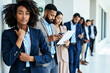 © MOTOKO Stock - Diverse Job Seekers Await Interviews: Multicultural Professionals in Modern Corporate Setting for HR & Recruitment