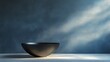 © ART IS AN EXPLOSION. - A black bowl sits on a table in front of a blue wall
