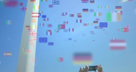 Poster - Hands holding smartphone, capturing various country flags animation over blue sky