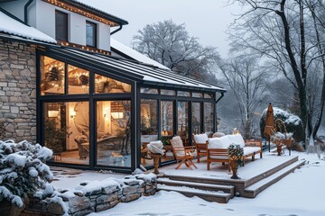 Traditional Modern Sunroom with Large Windows, Wooden Furniture on Snow-Covered Terrace and Stone-Walled Garden in Winter