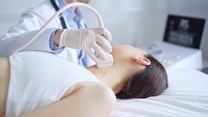 Doctor man is using ultrasound equipment on neck of female patient lying down for a medical examination. Medicine and science