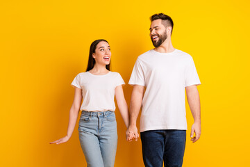 Canvas Print - Photo portrait of lovely young guy girl hold hands look each other dressed stylish white garment isolated on yellow color background