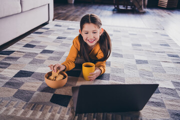 Canvas Print - Full length photo of little girl lying floor watch movie snacks drink tea dressed orange garment spend pastime spacious house indoors room