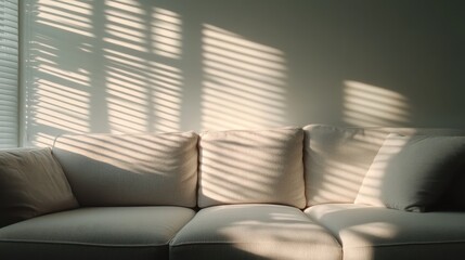 A cozy and inviting white couch is softly illuminated with light creating striped shadow patterns, producing a serene and calming environment ideal for relaxation.