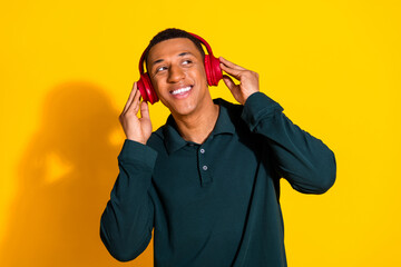 Poster - Photo portrait of handsome young guy headphones look empty space dressed stylish green garment isolated on yellow color background