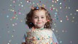 © Ilia - Child standing behind a birthday cake with confetti and glitter falling from above, set against a solid background. Festive and joyful atmosphere of Happy Birthday celebration.
