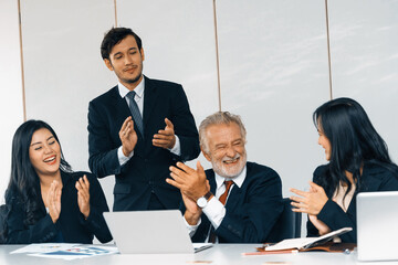 Wall Mural - Senior caucasian manager working in office with assistance of young Asian business people and translator in meeting. Corporate international business and secretary language translation concept. uds