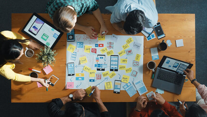 Fototapete - Top view of developer team sharing idea of Ux Ui design by using mind map. Top down view of group of business people working together to brainstorm or plan mobile phone interface app. Convocation.