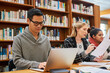 © TamJam/peopleimages.com - Laptop, typing and man in library for study with university, education and scholarship for growth. Books, online research and college student on campus with learning, knowledge and writing paper