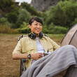© Miljan Živković - Mature japanese woman sit in front of tent and drink coffee enjoy