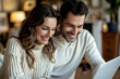 © Vera - man video conferencing with his happy wife on a laptop, capturing the intimacy and connection between the couple as they engage in an online meeting together.