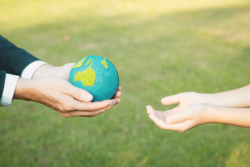 Wall Mural - Businessman hand giving Earth globe to little boy as Earth day concept as corporate social responsible to contribute greener environmental protection for sustainable future generation. Gyre