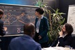 © DC Studio - Team members attending conference in a boardroom and presenting the situation, trying to detect challenges or obstacles hindering progress. Supervisor and staff struggling with a project.