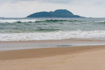 Wall Mural - The Tombo beach of Guaruja - SP, Brazil with the Farol da Moela island on background. Landscape of the beach with no people.