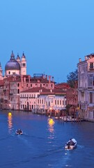 Wall Mural - View of Venice Grand Canal with boats and Santa Maria della Salute church in the evening from Ponte dell'Accademia bridge. Venice, Italy. Horizontal camera pan