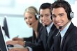 © InfiniteStudio - Business professionals using headsets to assist customers in a modern call center office during the workday