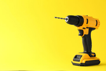 Sticker - Modern cordless electric drill on yellow background. Space for text