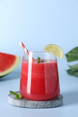 Canvas Print - Tasty watermelon drink in glass, mint and fresh fruit on light blue background