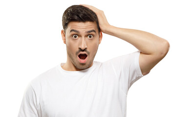 Young handsome man in white t-shirt touching head with hand, looking with amazed shocked eyes and open mouth