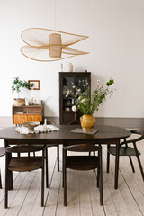 Wall Mural - Large oval table with a yellow vase of flowers in the center, surrounded by brown chairs