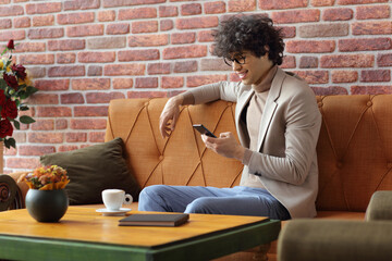 Poster - Young man in a cafe having a cup of coffee