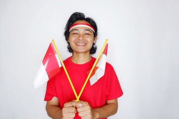 Portrait of an Indonesian man with long hair with a headband and red shirt celebrating Indonesian Independence Day with high nationalism on an isolated white background