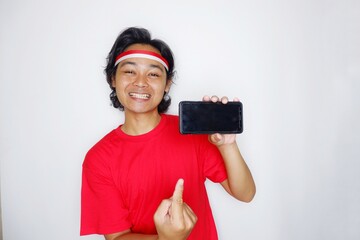 Portrait of an Indonesian man with long hair with a headband and red shirt celebrating Indonesian Independence Day with high nationalism on an isolated white background