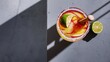 © Kartik - Selective focus of alcohol margarita cocktails with lime pieces and wooden squeezer on grey surface on white