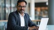 © Bijac - portrait of an indian businessman working on a laptop in a modern office setting professional attire and focused expression convey dedication and expertise in a global business context