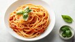 © ma - A white bowl of tomato pasta with basil leaves on the side, sitting on an isolated light gray background.