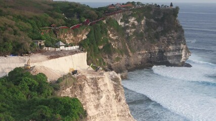 Wall Mural - Road construction in Uluwatu, Bali. The work of escalators and the destruction of the rock. Drone view