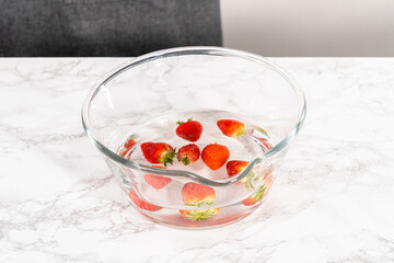 Poster - Preparing Strawberries in a Glass Mixing Bowl with Water