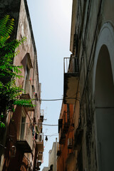 View of the street between two facades of houses with balconies