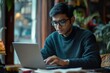 © Dilshad - Focused Indian Man Working on a Laptop Preparing Documents and Reviewing Data with Serious Attention