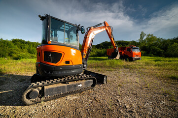 bulldozer stands on a piece of land against the backdrop of a bright blue sky and green trees. construction equipment ready to work