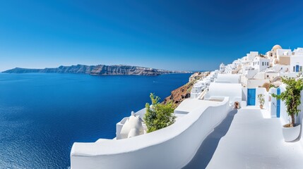 The panoramic view of Santorini white washed buildings overlooking the deep blue Aegean Sea, Greece