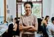 © HockleyM3/peopleimages.com - Woman, smile and portrait in creative office for startup, artist and happy for small business agency. Manager, workshop and art director or female person with arms crossed, project and entrepreneur