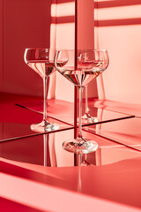 A reflection of three wine glasses on a red background