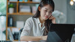 © MASstock - Asian female professional reviews data on a tablet device at her desk with office shelving in the background.