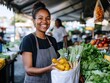 © Hanna - Smiling Female Vendor Holding Fresh Vegetables at Farmers Market Stall