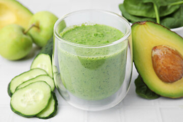 Canvas Print - Tasty green smoothie in glass and products on white tiled table, closeup