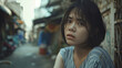 © Steven - Asian teenage girl with short black hair looks pensively at the camera while standing in a narrow alleyway with blurred background.